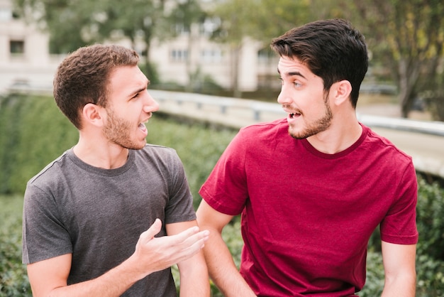 Friends in t-shirts talking at street