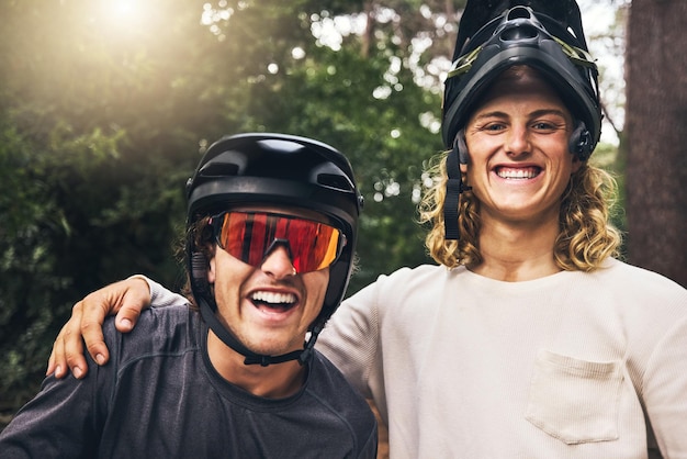 Friends taking a selfie together after cycling through nature trail in the forest Portrait of cyclist men from Sweden or Norway smiling wearing mountain biking helmets after bicycle ride in a park