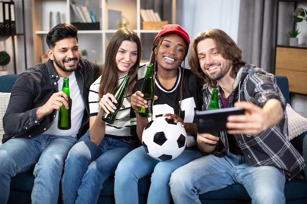 Friends taking selfie while watching football match