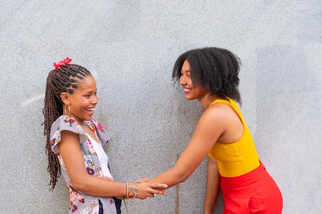 friends talking in the sunlight on the city street on a gray wall