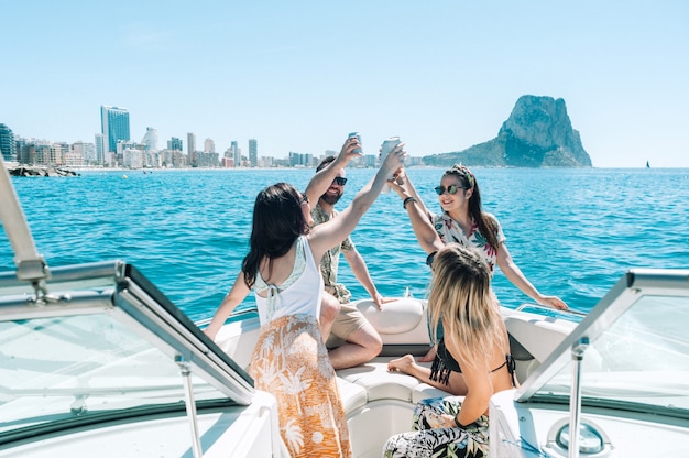 Friends toasting drinks in boat party