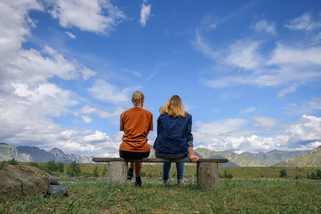 Friends travel, admire magnificent view of mountain range under blue sky on sunny day