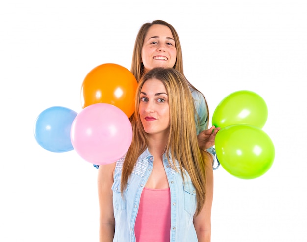 Friends with many balloons over white background