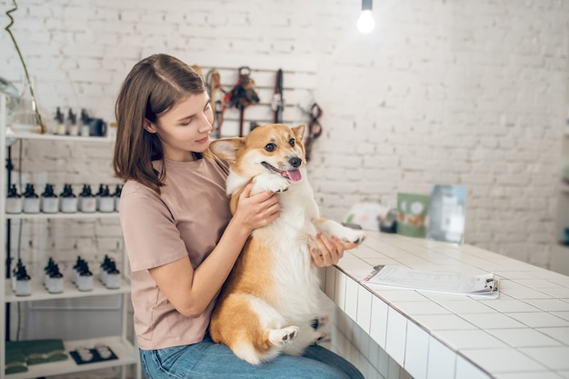 Friends. Young female pet owner holding her dog and feeling happy