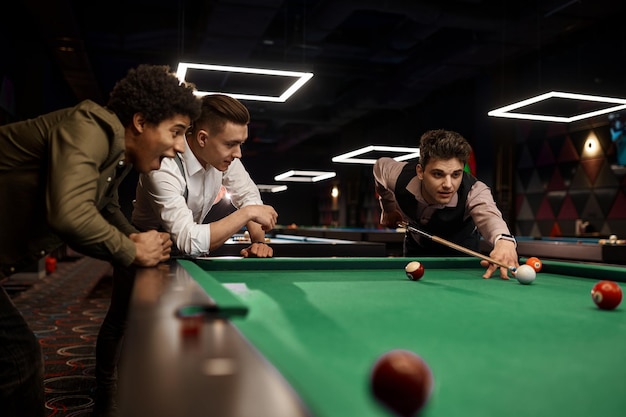 Friends young people group playing billiards together, nightlife club recreation