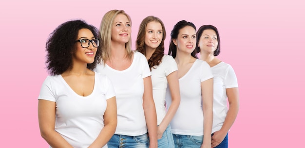 friendship, diverse, body positive and people concept - group of happy different size women in white t-shirts over pink background