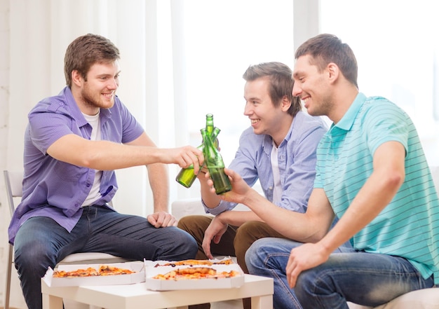 friendship, food and leisure concept - smiling male friends with beer and pizza hanging out at home