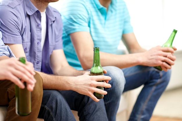 Photo friendship, leisure, people and alcohol concept - close up of happy male friends drinking beer at home