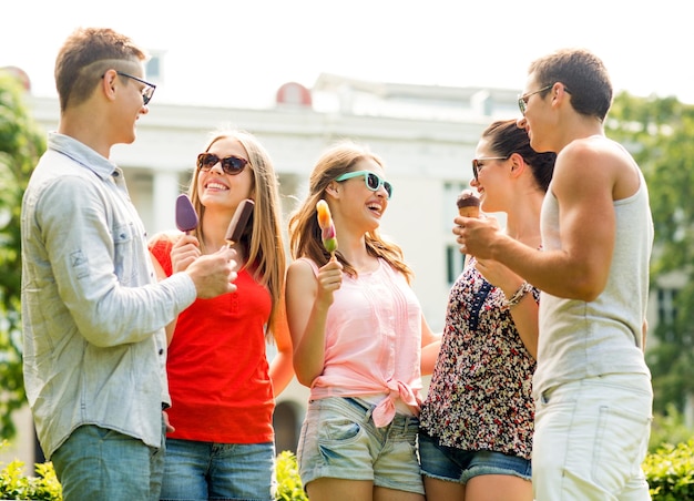 friendship, leisure, sweets, summer and people concept - group of smiling friends with ice cream outdoors