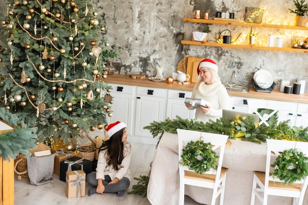 Friendship and love of mom and daughter. Family values. Preparing to celebrate Christmas. Christmas tree decoration. Building a good relationship between mother and daughter.