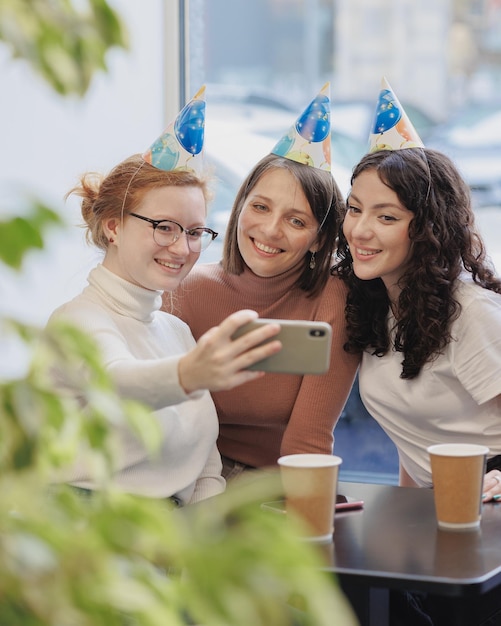 Friendship and support three women celebrate their birthday in a coffee shop restaurant and call