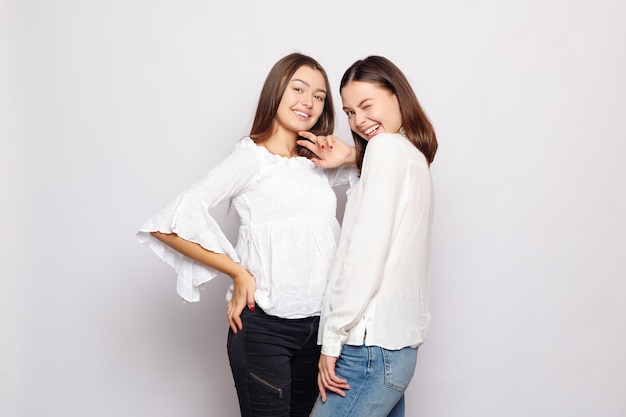 Friendship, t-shirt designe and happy people concept.  two laughing girls in white blank t-shirts