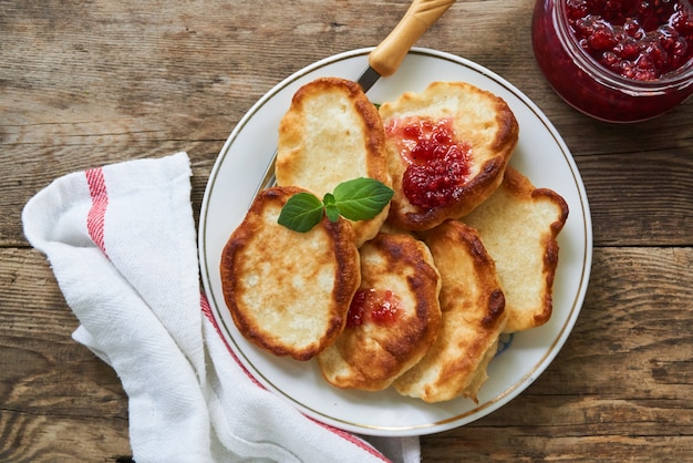 Fritters with raspberry jam on a white plate