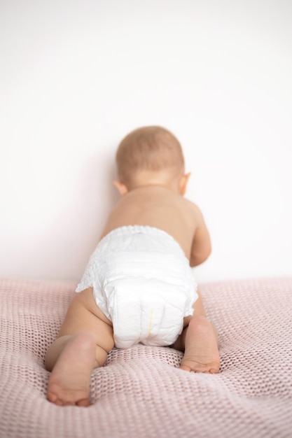 From the back A white diaper on a baby The legs of the child mockup space for text