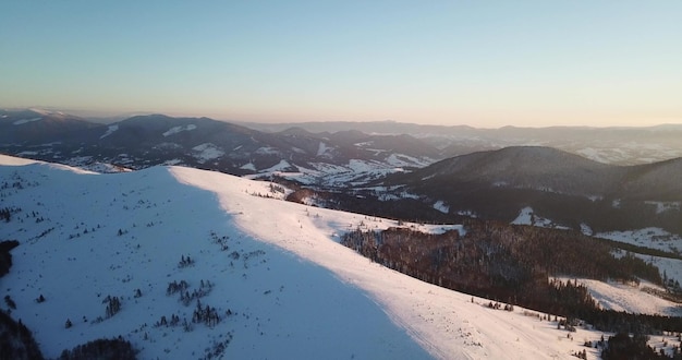 From great heigh fairytale mountain landscape snow covered alpine sharp peaks Wild winter in Carpathian mountains Ukraine Thick white clouds Open space Aerial 4K