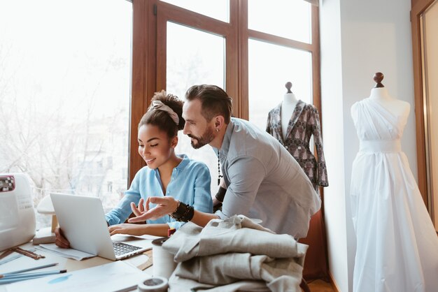 From paper to laptop man and woman at design studio