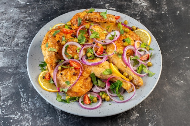 Front close view of delicious dinner fried chicken dish with various spices and foods on dark color background