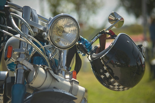 Front of a custom bike, with visible chrome, fanclub, and handlebar with helmet backing, motion ready to start the journey.