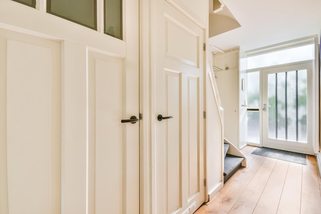 The front door of the house and a small corridor with other doors