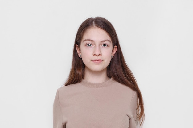 Front portrait of a beautiful teenage girl looking at camera isolated on a white background Copy space