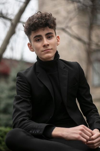 Front portrait of a smiling guy in front of a building with modern styling haircut City life style modern attitude