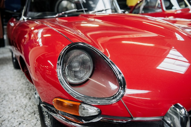 Front of the red vintage luxury car standing indoors at exhibition