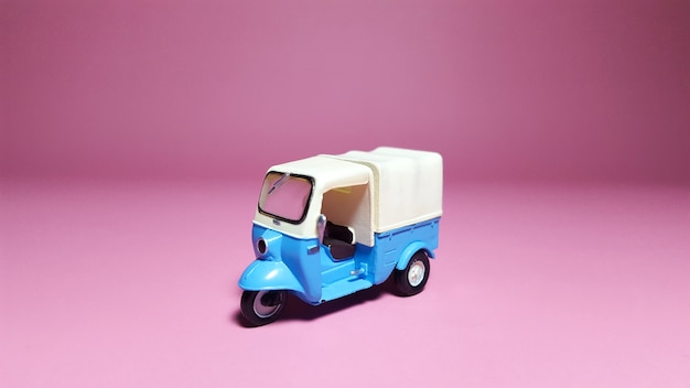 Front side of Tuk-tuk or blue vehicle on pink background