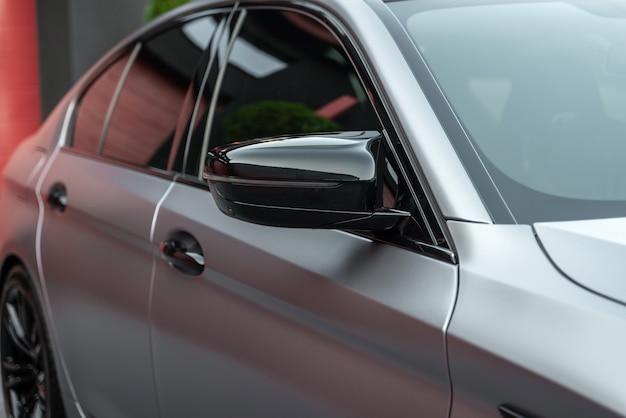 Front side view of the metallic color modern sports car close up Rearview mirror and doors