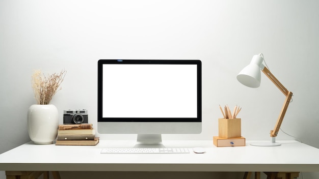 Front view of bank screen computer lamp camera and books on white table Blank screen for your webpage or advertise text