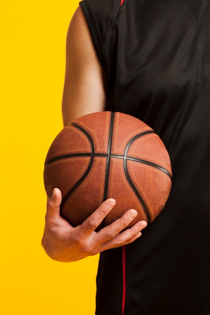 Front view of basketball held in one hand by male player