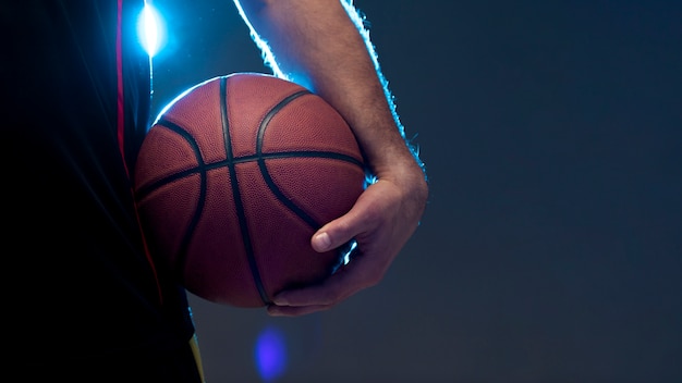 Front view of basketball player holding ball with copy space