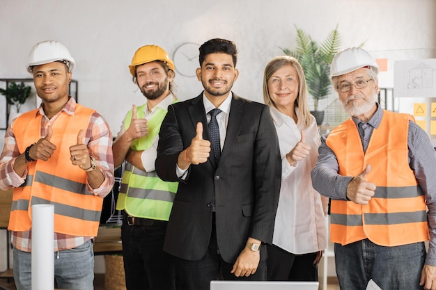 Front view of builders architects looking at camera while standing on light modern office