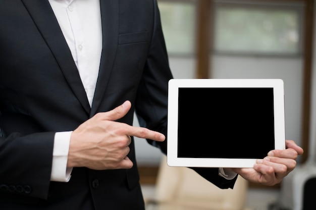 Front view of businessman pointing at tablet