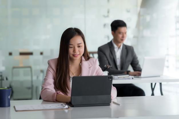 Front view of businesswoman using tablet notebook placed on the office table the back is blurry.