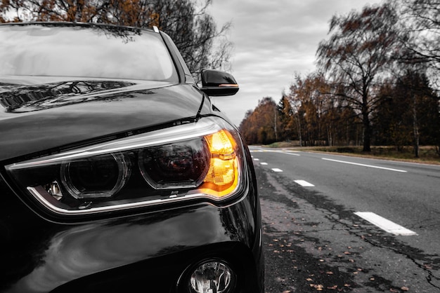 Front view of a car on the road starting to move after stopping and the left turn light on.