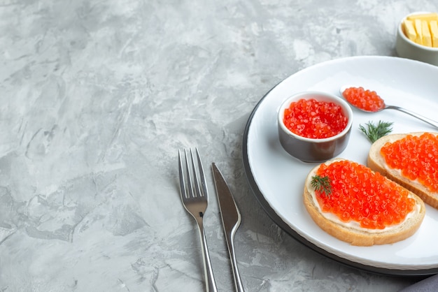 front view caviar sandwiches inside plate with cutlery on white surface