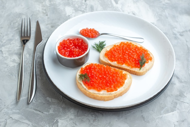 front view caviar sandwiches inside plate with cutlery on white surface