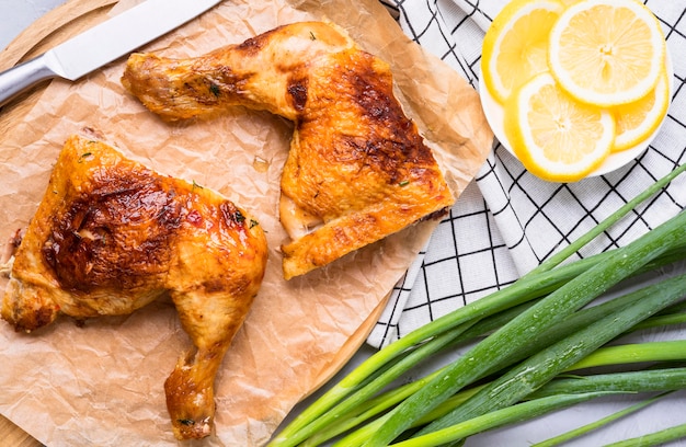 Front view chicken legs with lemon slices and green onion