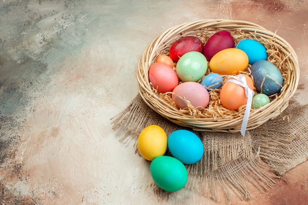 front view colored easter eggs inside basket on light surface