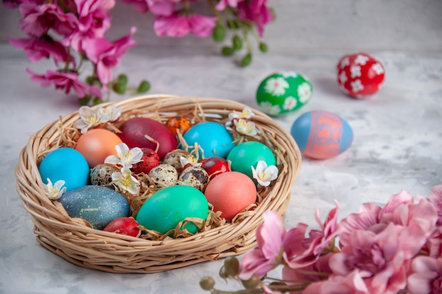 front view colored easter eggs inside basket on white surface spring colourful ornate easter concept flower