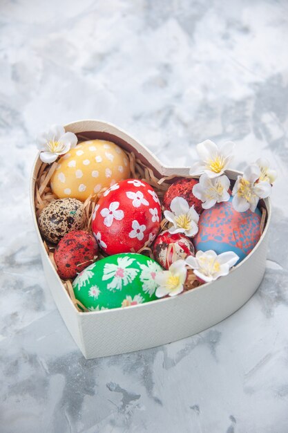 front view colored easter eggs inside heart shaped box on white surface concept colourful spring holiday paint ornate