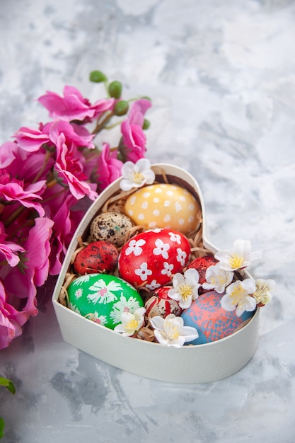 front view colored easter eggs inside heart shaped box with flowers white surface colourful holiday ornate spring concept