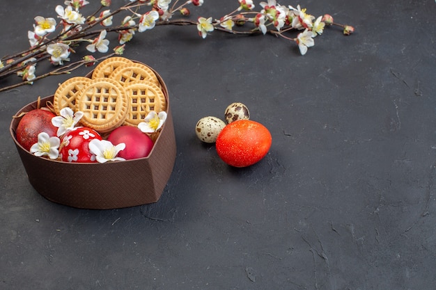 front view colored easter eggs with cookies inside heart shaped box on dark surface holiday ornate easter colourful concept bird colour spring