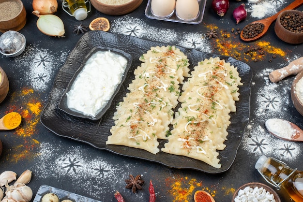 Front view cooked meat dumplings with different ingredients on dark background vegetable dish cooking meal color dough dinner pepper