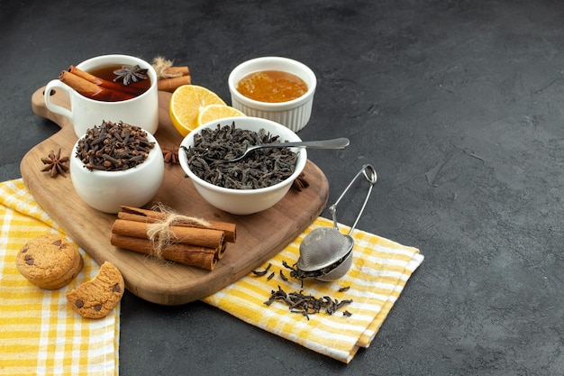 Front view cup of tea with black tea honey and lemon slices on a dark background morning coffee table breakfast egg family meal