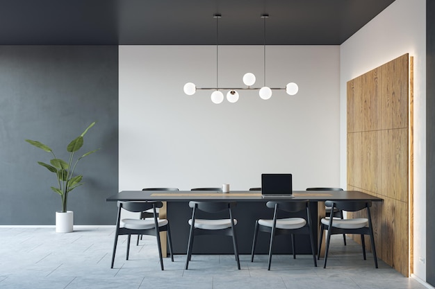 Front view on dark conference table with laptop and chairs around on concrete floor in spacious meeting office room with backlit wooden decoration and white and grey wall background 3D rendering