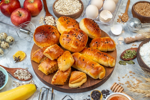 front view delicious buns with pastries cereals and eggs on white background dough pie fruit cook cake milk pastry bake