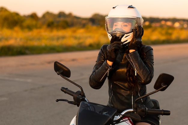 Front view of female motorcycle rider with helmet on