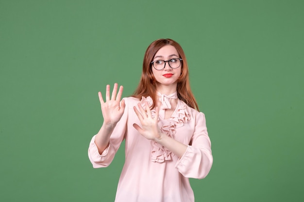 Front view female teacher in pink blouse on green background book student job college color work library woman young lesson