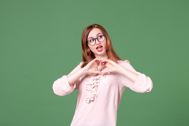 Front view female teacher in pink blouse on green